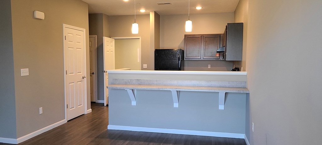 a view of a kitchen and a living room from behind a bar