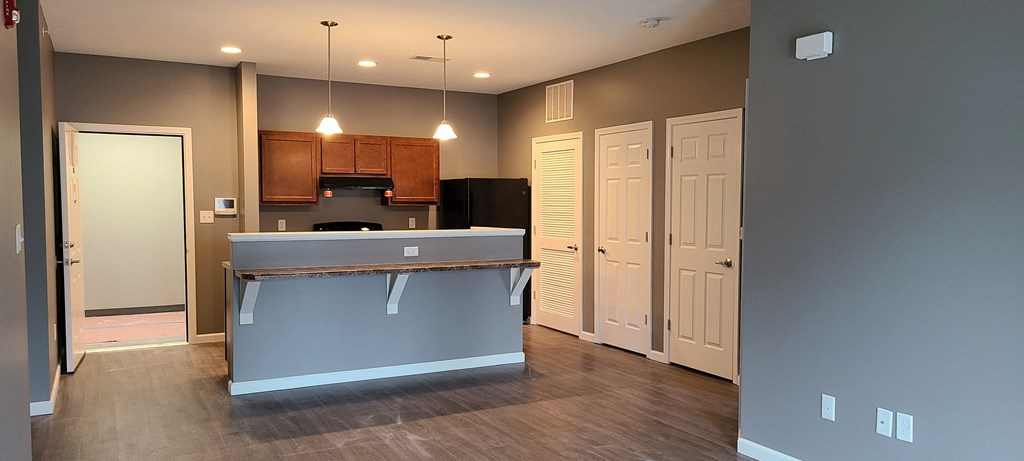 a kitchen with a blue island and a door to a hallway
