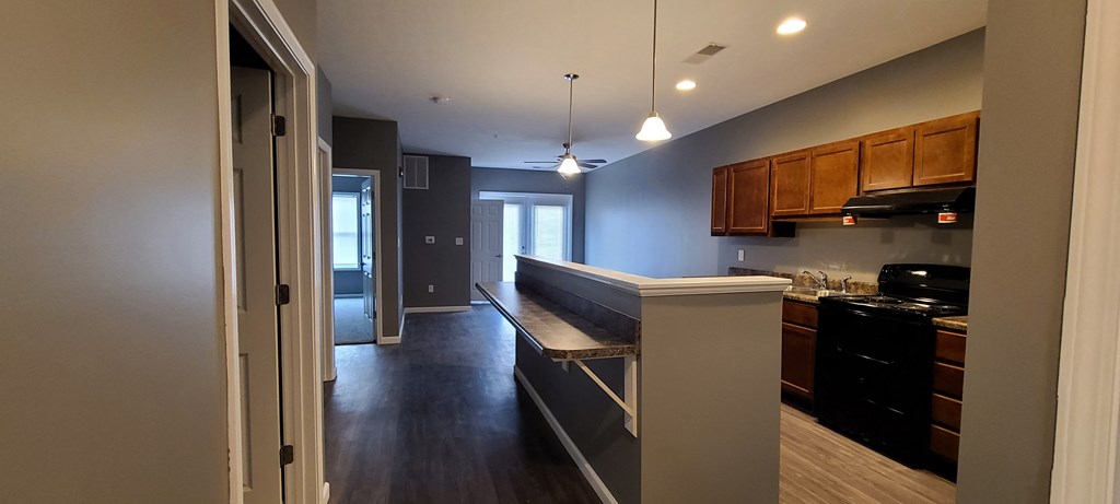 a kitchen with a long counter and a door to a hallway