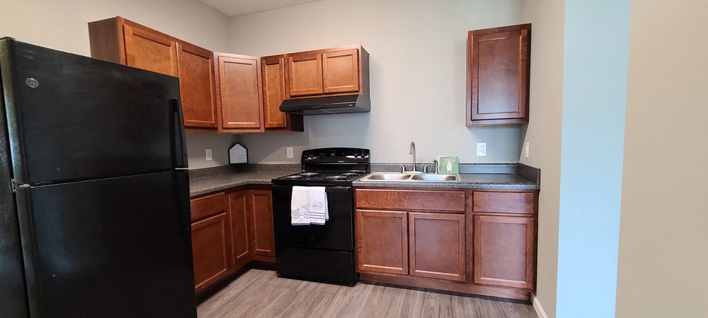 a kitchen with black appliances and wooden cabinets