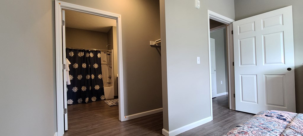 a bedroom with a closet and an open door to a bathroom