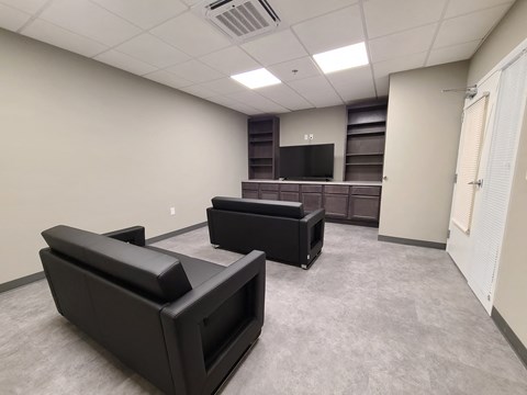 a living room with couches and a television in a building