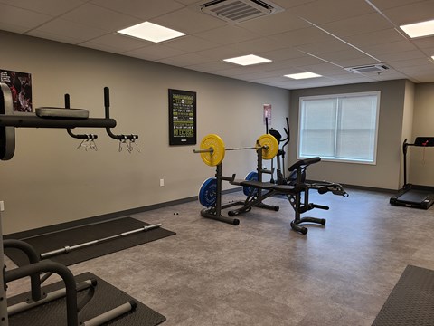 a fitness room with weights and other exercise equipment