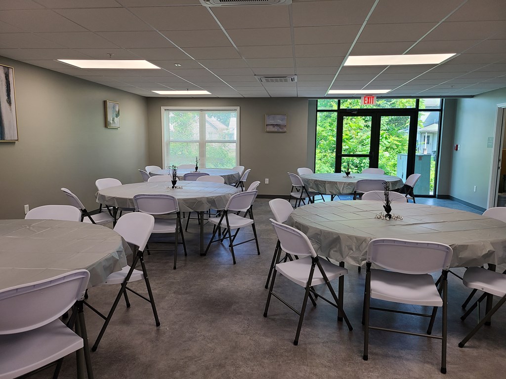 a dining room with tables and chairs in a room with windows