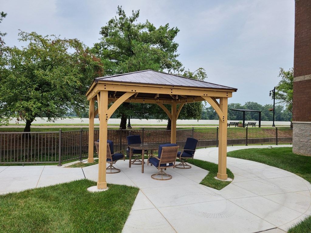 a patio with a gazebo and a table and chairs