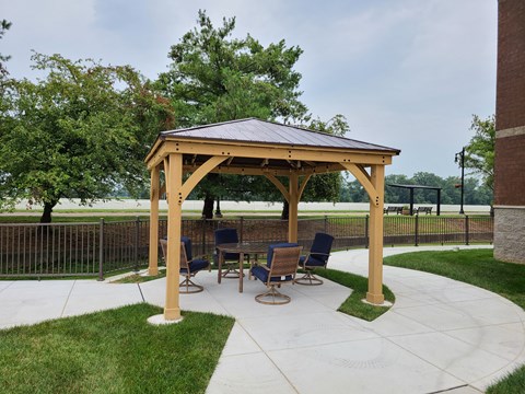 a patio with a gazebo and a table and chairs