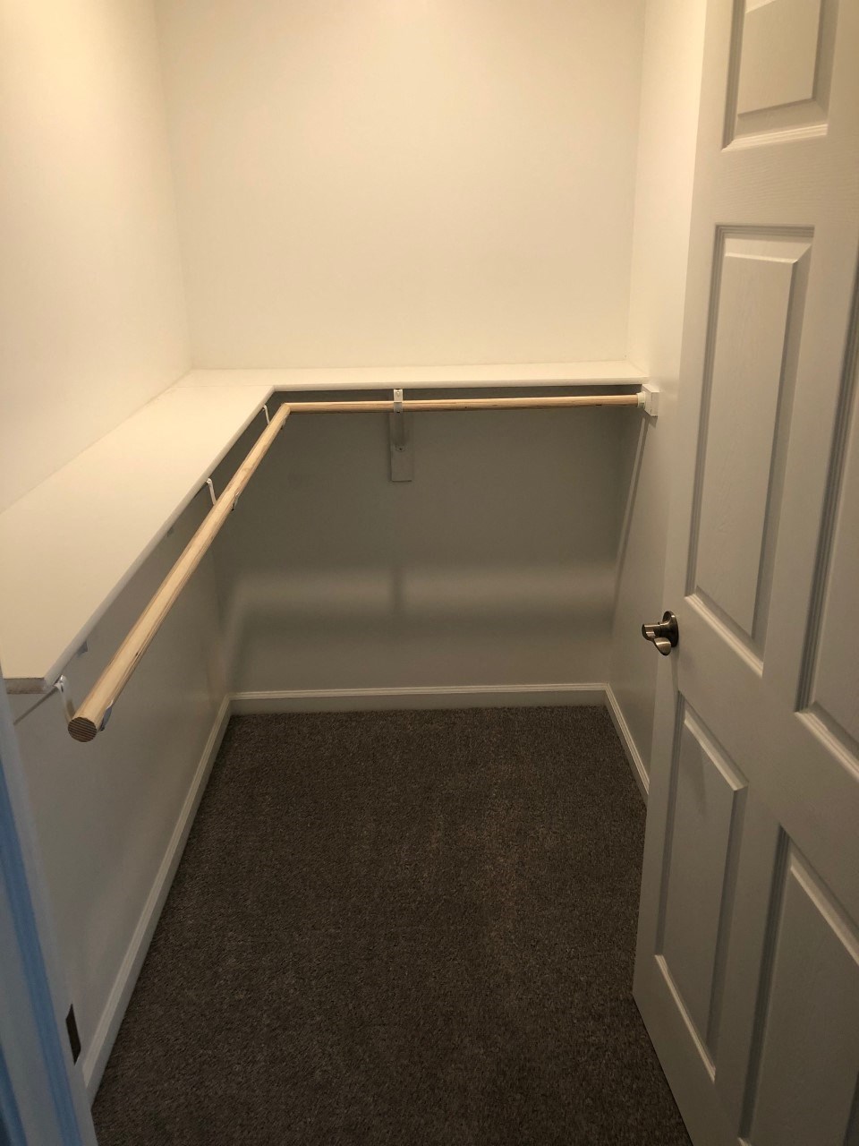 an empty room with a rail on the wall and a carpeted floor