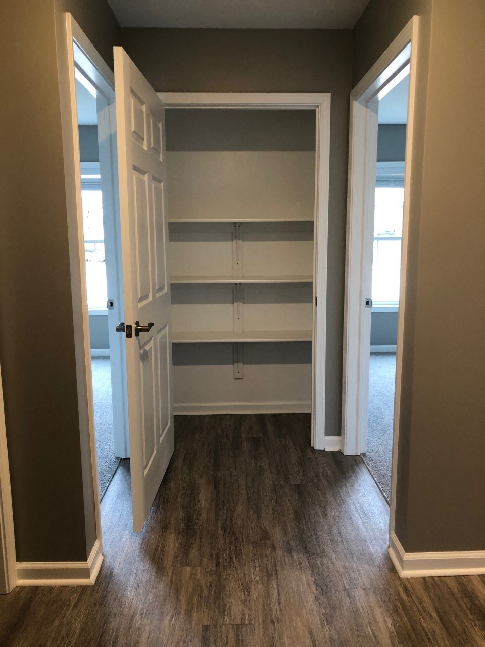 a walk in closet with shelves and an open door