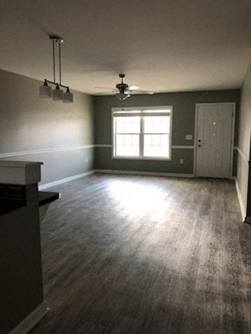 an empty living room with a window and a door