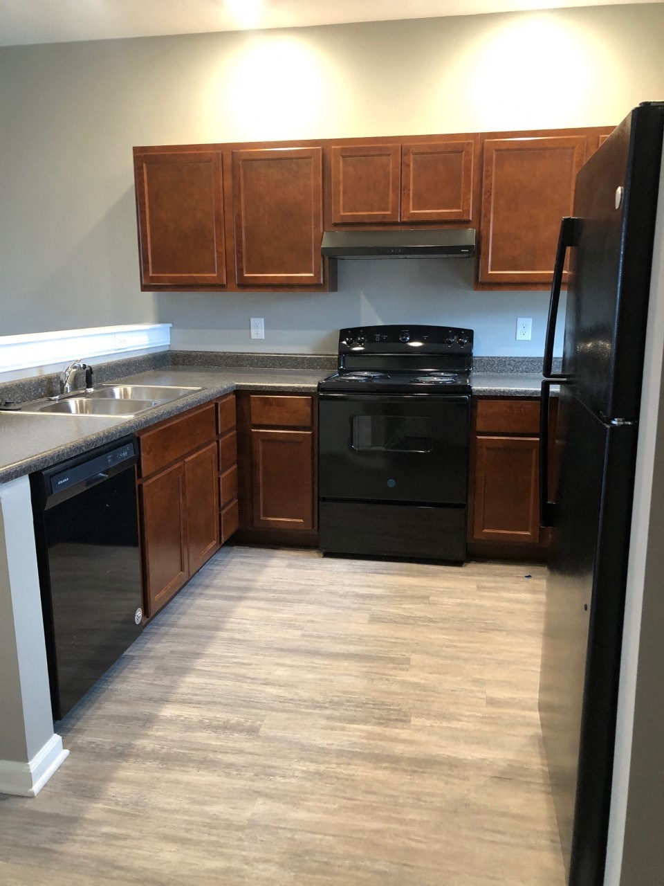 a kitchen with black appliances and wooden cabinets