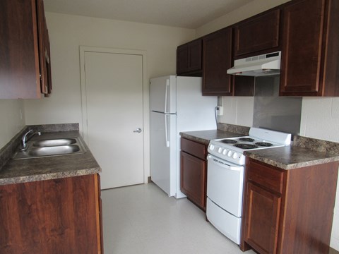 a kitchen with white appliances and wooden cabinets
