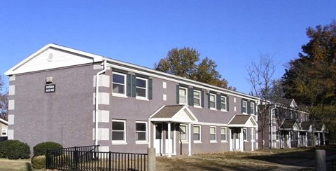 a brick building with windows and a fence in front of it