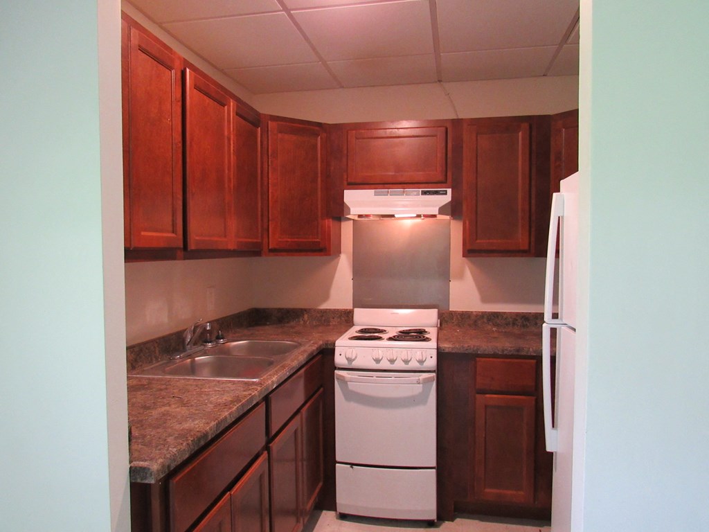 a kitchen with wooden cabinets and white appliances