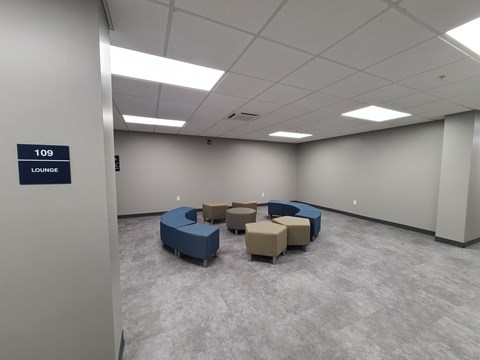 a large room with blue couches and chairs and white walls
