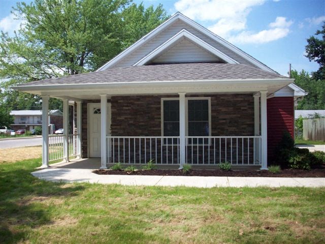 a small brick house with a porch and a