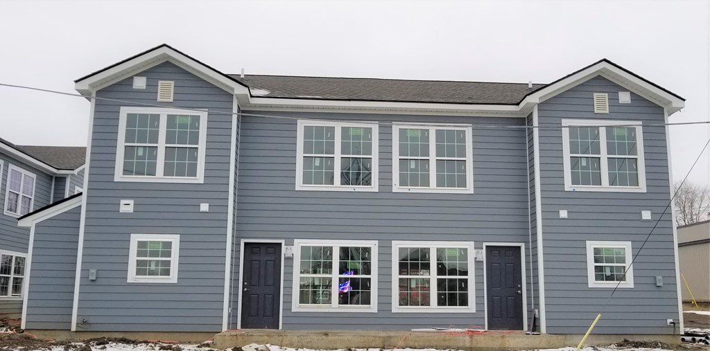 a blue house with windows and a front yard