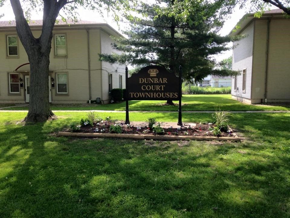 a sign in the grass in front of a building