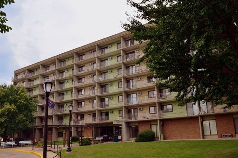 a large apartment building with a lawn in front of it