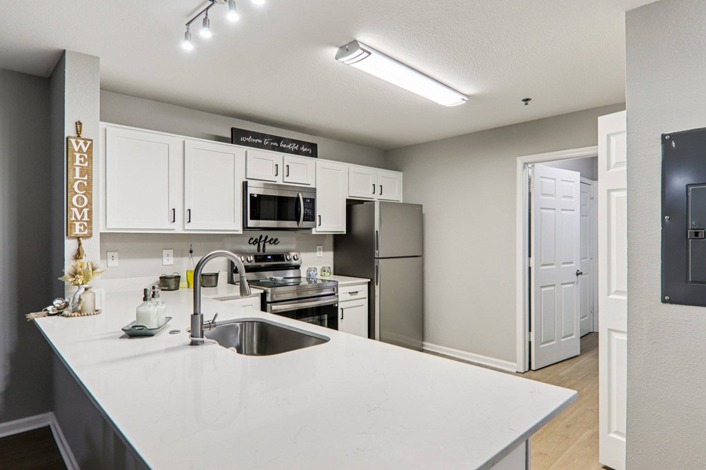 A kitchen with a white countertop and a sign that says "welcome".