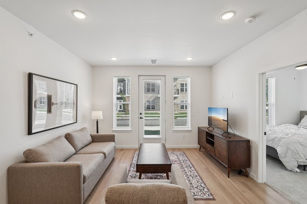 A well-lit living room with a couch, coffee table, and television.