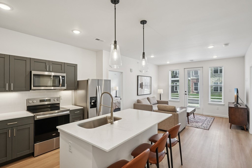 A modern kitchen with a large island and stainless steel appliances.
