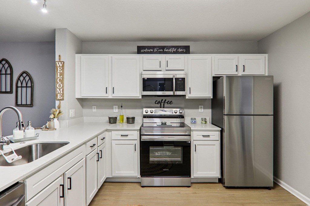 A kitchen with a stove top oven and a refrigerator.