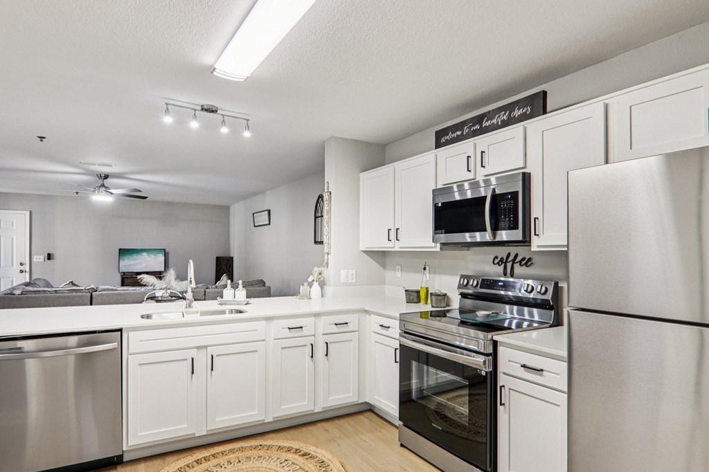 A modern kitchen with white cabinets and stainless steel appliances.