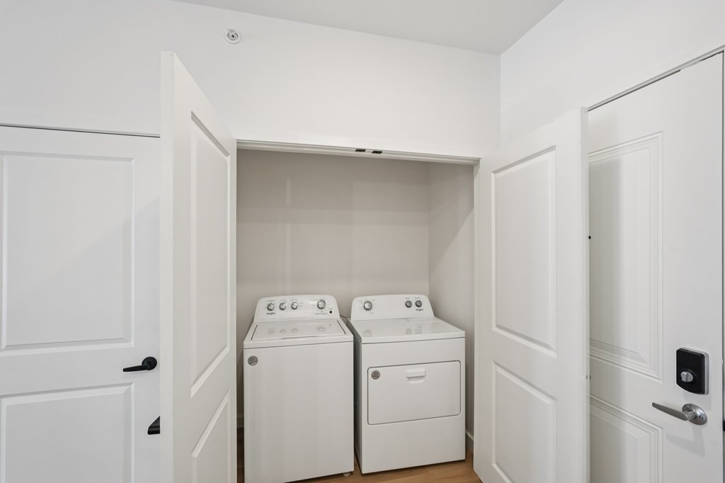 A white laundry room with two washing machines.