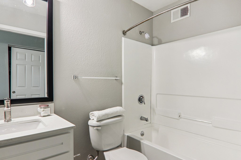A white bathroom with a toilet, sink, and bathtub.