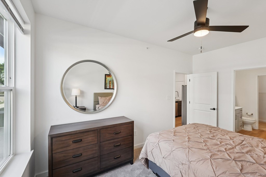 A bedroom with a bed, dresser, and mirror.