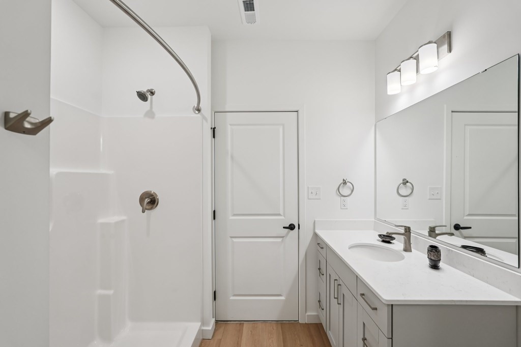 A white bathroom with a white tub and sink.