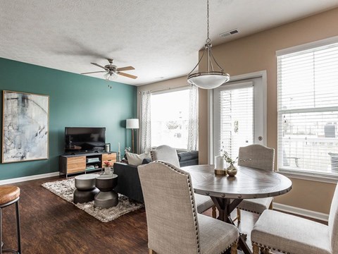 A living room with a grey sofa, a round table and a television.