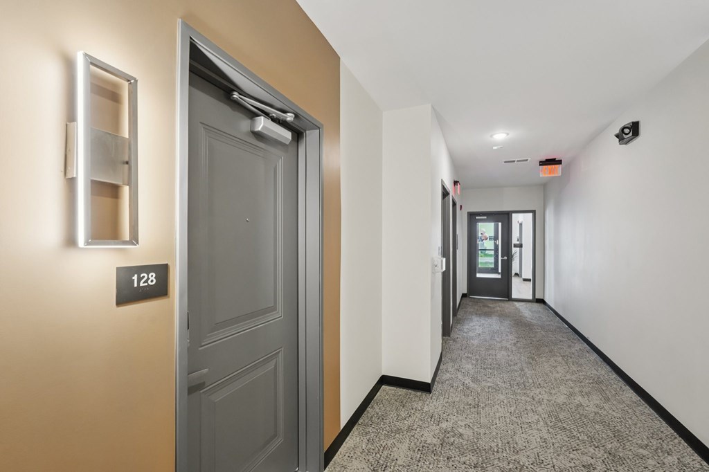 A hallway with a door numbered 128.