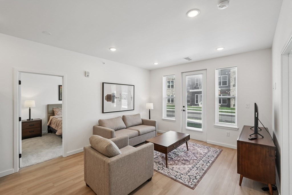 A living room with a couch, a coffee table, and a television.