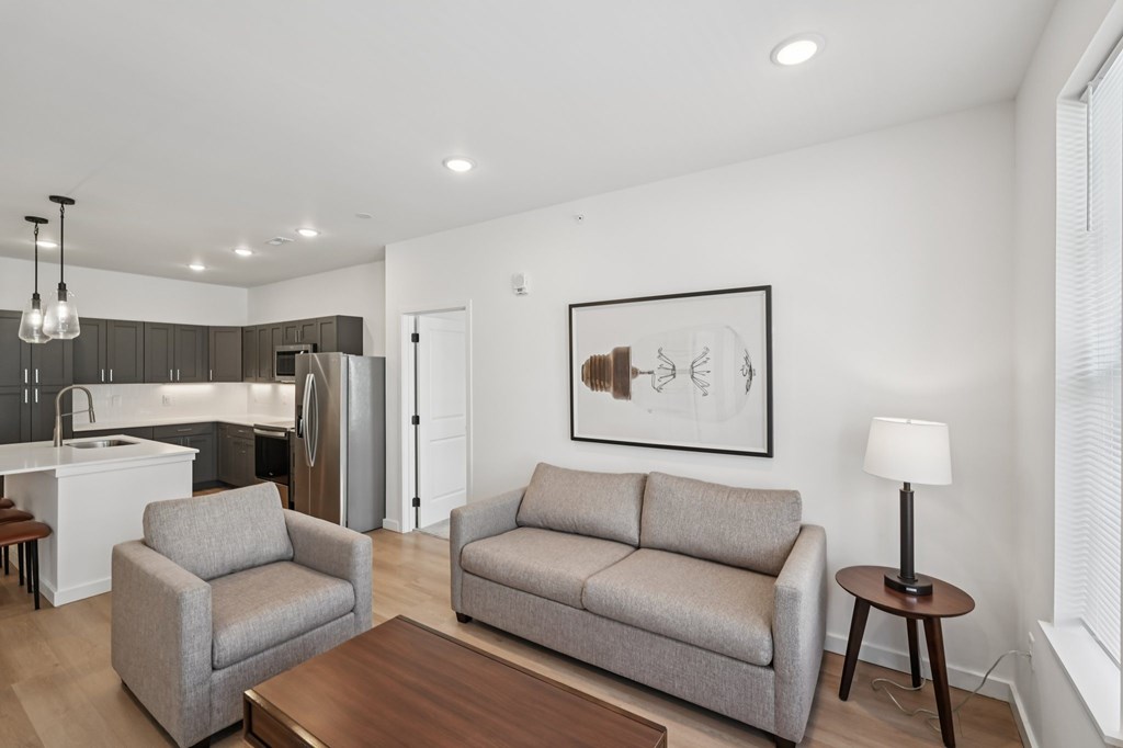 A modern living room with a grey couch and a wooden coffee table.