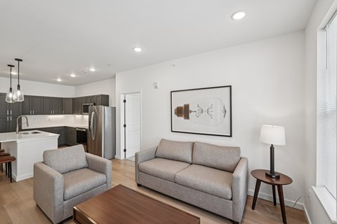A modern living room with a grey couch and a wooden coffee table.