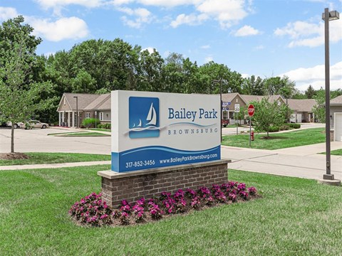 A sign for Bailey Park in Brownsburg stands in front of a building.