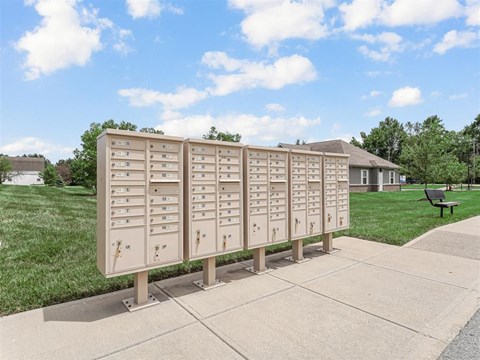A row of mailboxes are lined up on a sidewalk.