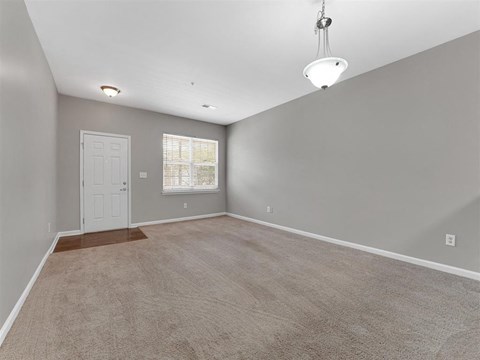 A room with a door, window, and carpeted floor.
