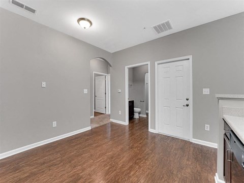 A room with a white door and a wooden floor.
