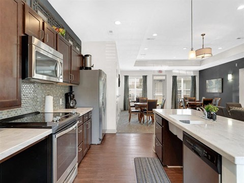 A modern kitchen with dark wood cabinets and stainless steel appliances.