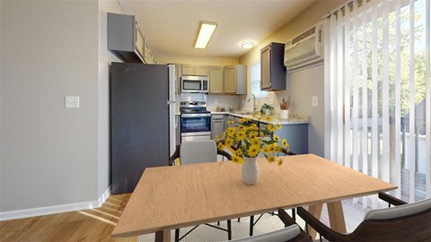 A kitchen with a table and chairs in front of it.