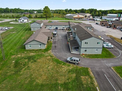 A parking lot with a few cars and a building in the background.