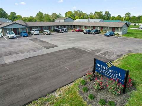 A parking lot with cars and a sign that says Windmill.