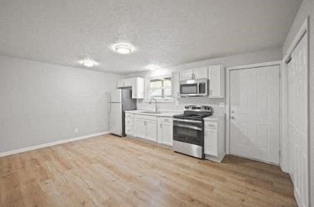 A kitchen with white cabinets and stainless steel appliances.