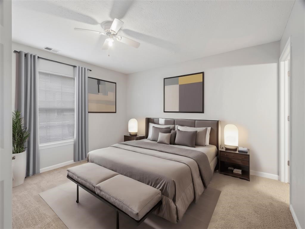 A bedroom with a large bed and a ceiling fan.