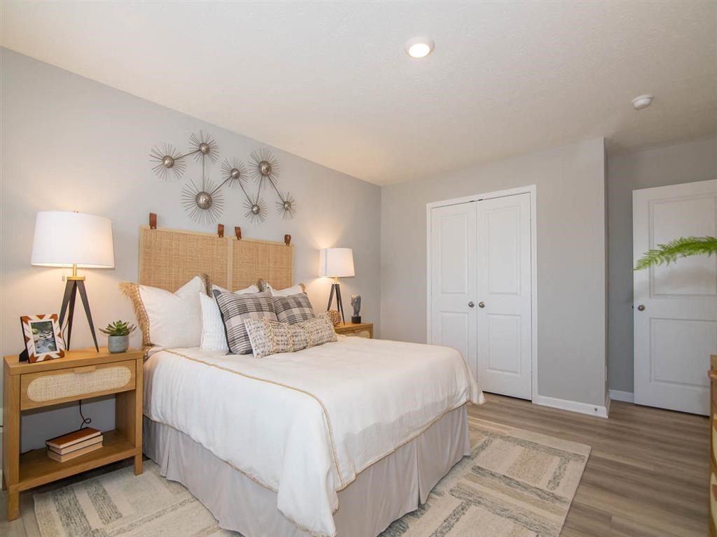 A bedroom with a large bed and two lamps on either side.