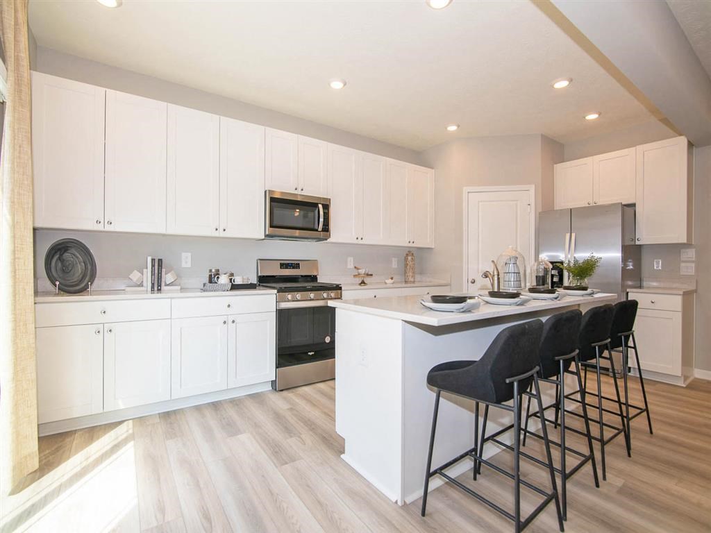 A modern kitchen with white cabinets and a large island.