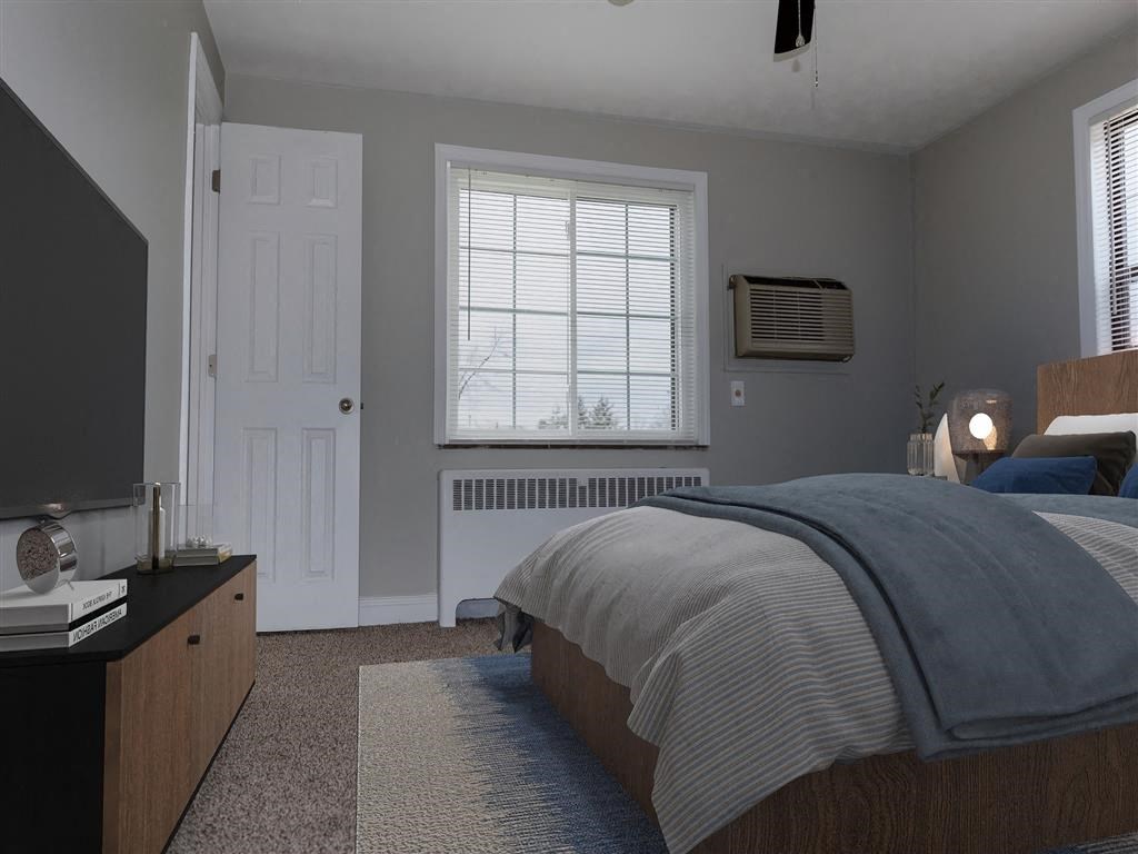 A bedroom with a bed, nightstand, and window at Huntley Ridge Apartments, Ohio