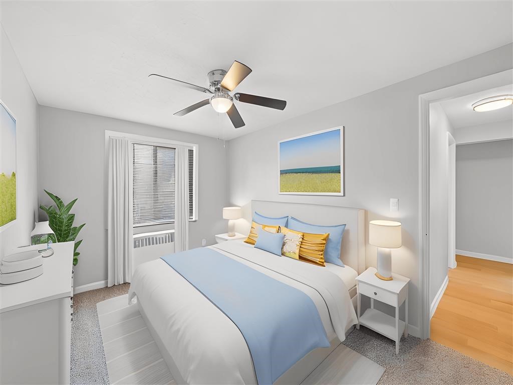 A bedroom with a bed, nightstands, and a ceiling fan at Huntley Ridge Apartments, Ohio
